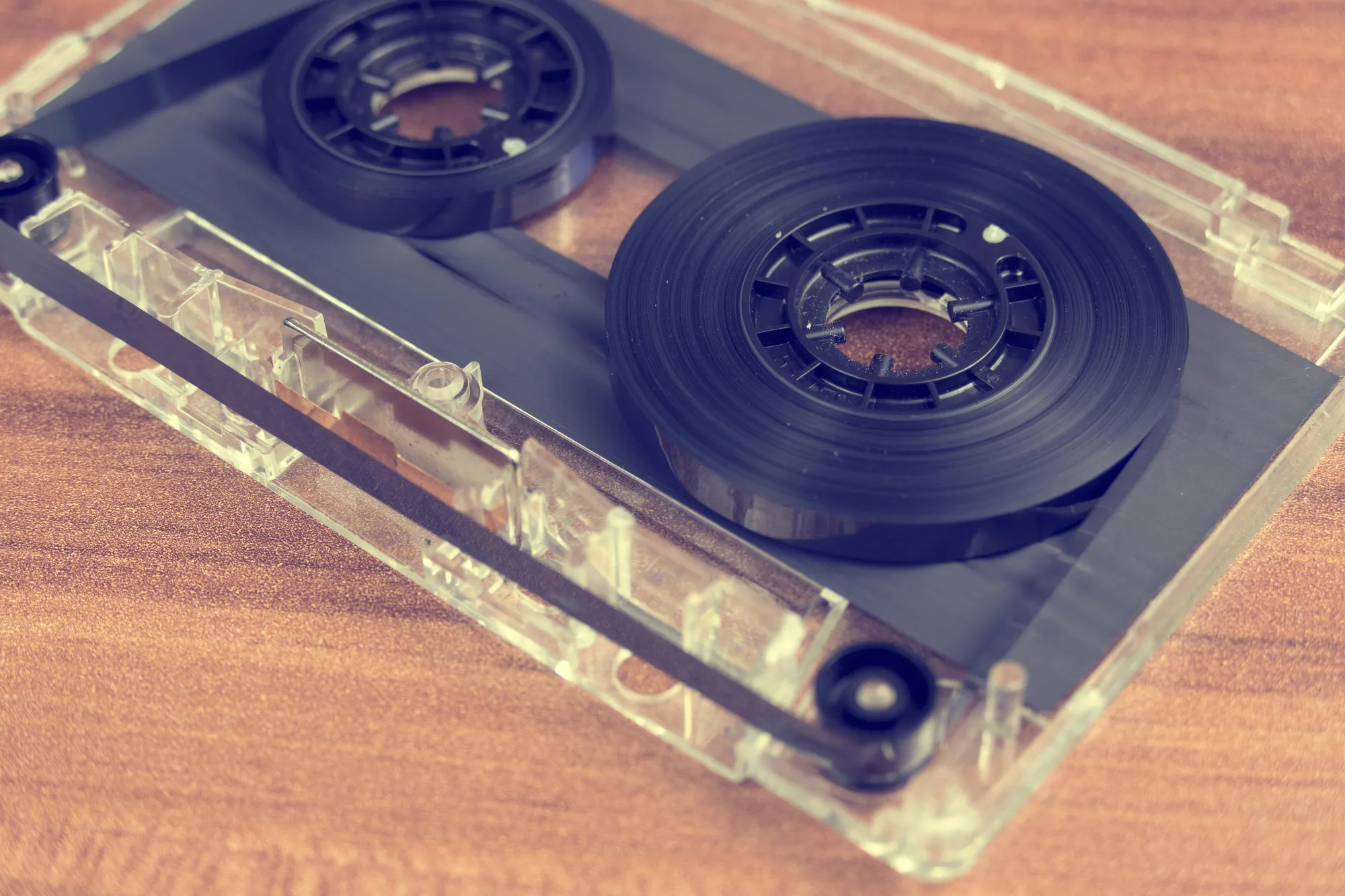 Detailed close-up of a retro audio cassette tape on a wooden surface.